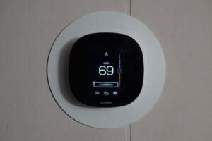 A thermostat displays the temperature in a home and relays heating instructions to the furnace.